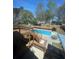 Aerial view of a backyard featuring an in-ground pool, spacious patio, and a wooden deck, ideal for outdoor living at 321 Roses Creek Dr, Lawrenceville, GA 30044