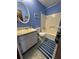 Well-lit bathroom with blue walls featuring a shower-tub combo, vanity sink, toilet, and modern fixtures at 321 Roses Creek Dr, Lawrenceville, GA 30044