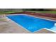 Sparkling in-ground pool with a concrete surround and wood retaining wall in a private backyard setting at 321 Roses Creek Dr, Lawrenceville, GA 30044