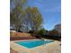 Backyard in-ground swimming pool surrounded by patio, fence, and trees at 321 Roses Creek Dr, Lawrenceville, GA 30044