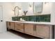 Modern bathroom boasts double vanity, wood cabinets, and a sleek, green tile backsplash at 1168 Mado Loop, Chattahoochee Hills, GA 30268