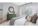 Inviting bedroom with a decorative mirror, large window and view of wooded area at 1168 Mado Loop, Chattahoochee Hills, GA 30268