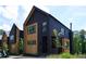 Modern home featuring dark siding, natural wood accents, and a minimalist design under a partly cloudy sky at 1168 Mado Loop, Chattahoochee Hills, GA 30268