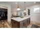 Open-concept kitchen with a large island, pendant lighting, and seamless flow to the living area at 1168 Mado Loop, Chattahoochee Hills, GA 30268