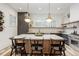 Modern kitchen features a large island with seating, stylish pendant lights, and stainless steel appliances at 1168 Mado Loop, Chattahoochee Hills, GA 30268