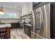 Modern kitchen with stainless steel appliances, dark cabinetry, and a large island with pendant lighting at 1168 Mado Loop, Chattahoochee Hills, GA 30268
