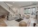 Bright, open living room with a comfortable sofa, stylish chairs, large windows, and a staircase at 1168 Mado Loop, Chattahoochee Hills, GA 30268