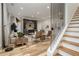 Open-concept living room features a staircase, stylish furniture, and a built-in bar area at 1168 Mado Loop, Chattahoochee Hills, GA 30268