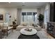 Sunlit living room offers lounge seating, modern furnishings, and an indoor tree for a relaxing atmosphere at 1168 Mado Loop, Chattahoochee Hills, GA 30268