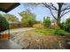 Backyard featuring a stone patio, wood fence, shed, and mature trees at 1420 Elizabeth Ln, East Point, GA 30344