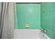 Retro bathroom with green tiles, a shower curtain, and a white bathtub at 1420 Elizabeth Ln, East Point, GA 30344