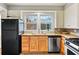This kitchen features a stainless-steel dishwasher, black refrigerator, butcher block counters, and double window over sink at 1420 Elizabeth Ln, East Point, GA 30344