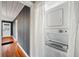 Efficient laundry area with stacked washer and dryer, nestled in a hallway with hardwood floors at 1420 Elizabeth Ln, East Point, GA 30344