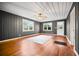 Bright living room features hardwood floors, paneled walls, ceiling fan, and a door to the outside at 1420 Elizabeth Ln, East Point, GA 30344