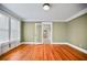 Bright living room with hardwood floors, fresh paint, and a view into the adjacent room through a glass door at 1420 Elizabeth Ln, East Point, GA 30344