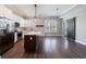 The kitchen with white cabinets, stainless appliances, dark island, and wood floors flows into the dining area and barn door at 2620 Oak St, Atlanta, GA 30344