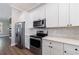 Close-up of white kitchen features modern appliances, and countertops, creating a clean and functional cooking space with wood floor at 2620 Oak St, Atlanta, GA 30344