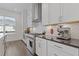 Bright kitchen with white cabinets, stainless steel appliances, dark countertops, and a herringbone backsplash at 312 Concord St, Alpharetta, GA 30009