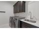 Laundry room with gray cabinets, modern appliances, sink and white countertops at 312 Concord St, Alpharetta, GA 30009
