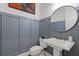 Chic powder room with blue accent wall, pedestal sink, and round mirror at 312 Concord St, Alpharetta, GA 30009