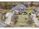 Expansive aerial view of a brick two-story home, landscaped front yard, and wide driveway at 7090 Blue Sky Drive, Locust Grove, GA 30248
