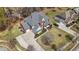 Aerial shot of a brick home with a lush green lawn, complemented by a paved driveway and mature trees at 7090 Blue Sky Drive, Locust Grove, GA 30248