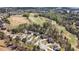 Stunning aerial view showcasing a neighborhood with lush trees, homes, and a golf course in the distance at 7090 Blue Sky Drive, Locust Grove, GA 30248