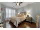 This bedroom features hardwood floors, a large window and a ceiling fan at 7090 Blue Sky Drive, Locust Grove, GA 30248