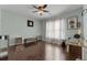A large room with hardwood floors, light blue walls, a fan and sheer curtains at 7090 Blue Sky Drive, Locust Grove, GA 30248