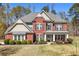 Inviting red brick home with manicured lawn, stone accents, and a charming front porch at 7090 Blue Sky Drive, Locust Grove, GA 30248
