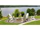 Lakeside fire pit with Adirondack chairs and lush greenery, perfect for outdoor relaxation at 7090 Blue Sky Drive, Locust Grove, GA 30248