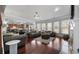 Open-concept living room with hardwood floors, large windows, and elegant furnishings at 7090 Blue Sky Drive, Locust Grove, GA 30248