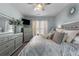 Stylish bedroom offers a ceiling fan, TV, dresser, and a large window for natural light at 7090 Blue Sky Drive, Locust Grove, GA 30248