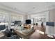 Home office with large windows, a modern desk, and classic wainscoting details at 7090 Blue Sky Drive, Locust Grove, GA 30248