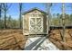Charming outbuilding with a neutral color and classic door design, nestled in a natural setting at 7090 Blue Sky Drive, Locust Grove, GA 30248