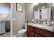 Stylish powder room with a granite counter, dark wood vanity and decorative mirror at 7090 Blue Sky Drive, Locust Grove, GA 30248