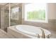Bright bathroom features a soaking tub next to a glass shower enclosure at 8245 Dawson View Way, Cumming, GA 30028
