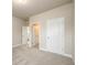 Bright bedroom featuring neutral carpeting, white doors, and light beige walls at 8245 Dawson View Way, Cumming, GA 30028