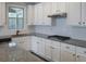 Granite countertops and stainless appliances complement the white cabinetry in this kitchen at 8245 Dawson View Way, Cumming, GA 30028