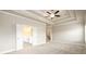 Large main bedroom featuring coffered ceiling, carpet and doors to en-suite bathroom at 8245 Dawson View Way, Cumming, GA 30028