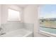 Bright bathroom with a tub and a window at 1099 Blue Juniper Cir, Loganville, GA 30052
