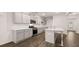 Modern kitchen features gray cabinets, stainless steel appliances, quartz countertops, and hardwood floors at 1099 Blue Juniper Cir, Loganville, GA 30052