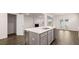 Kitchen island featuring a stainless steel sink, gray cabinets, and an open view into the living area with a fireplace at 1099 Blue Juniper Cir, Loganville, GA 30052