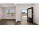 A view of the living room with wood floors shows the front door and a large window at 1099 Blue Juniper Cir, Loganville, GA 30052