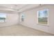 A bright main bedroom features plush carpeting, a ceiling fan, and three windows that let in natural light at 1099 Blue Juniper Cir, Loganville, GA 30052