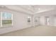 A bright main bedroom features plush carpeting, a ceiling fan, and three windows that let in natural light at 1099 Blue Juniper Cir, Loganville, GA 30052