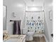 Bright bathroom featuring granite countertop vanity and shower with floral patterned curtain for added style at 1115 Martin Luther King Jr Sw Dr, Atlanta, GA 30314