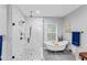 Beautiful bathroom featuring a glass shower, freestanding tub, sleek fixtures, and natural light from window at 1115 Martin Luther King Jr Sw Dr, Atlanta, GA 30314