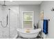 Elegant bathroom featuring a freestanding tub, a glass-enclosed shower, and modern black fixtures at 1115 Martin Luther King Jr Sw Dr, Atlanta, GA 30314