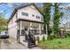 Exterior shot featuring a two-story home with black and white accents, a charming porch, and well-maintained landscaping at 1115 Martin Luther King Jr Sw Dr, Atlanta, GA 30314